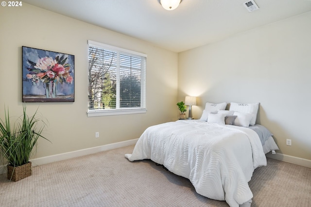 carpeted bedroom with visible vents and baseboards