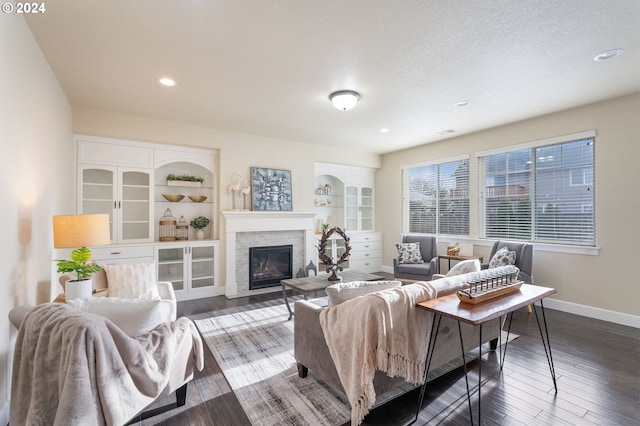 living room with visible vents, baseboards, a fireplace, hardwood / wood-style flooring, and a textured ceiling