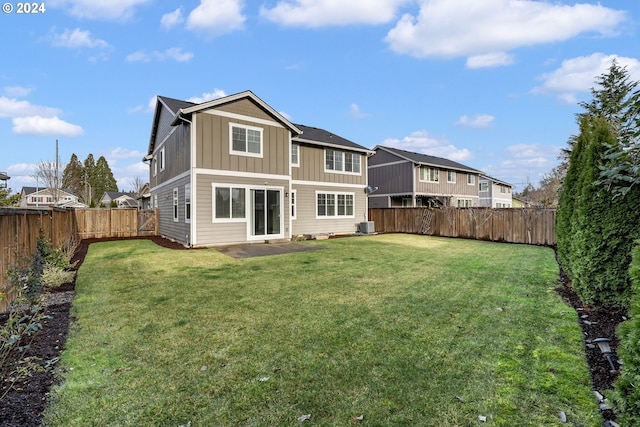 rear view of house with central air condition unit, a lawn, a patio, a fenced backyard, and board and batten siding