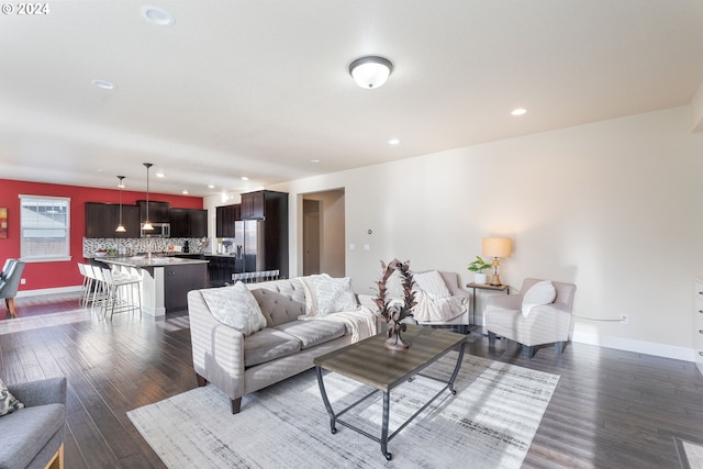 living area featuring recessed lighting, baseboards, and dark wood-style floors