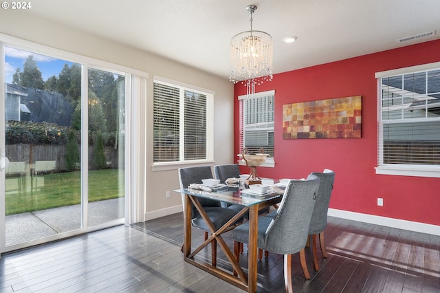 dining space featuring visible vents, an inviting chandelier, baseboards, and wood finished floors