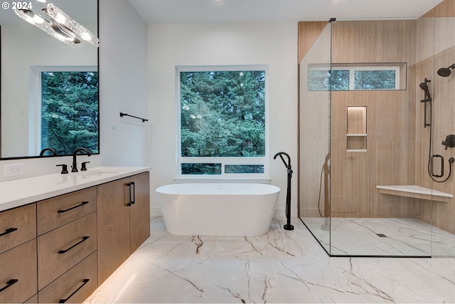 full bath with a shower stall, vanity, marble finish floor, and a freestanding tub