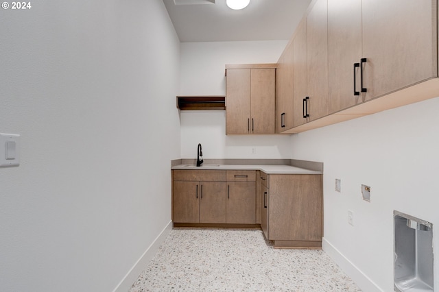 laundry area with hookup for a washing machine, cabinet space, baseboards, and a sink