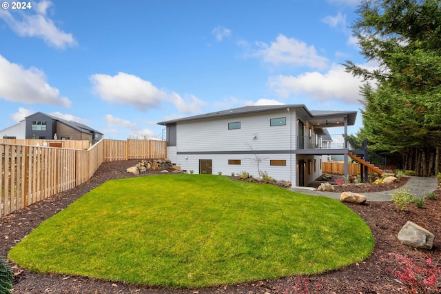 back of property featuring a lawn, stairs, and a fenced backyard