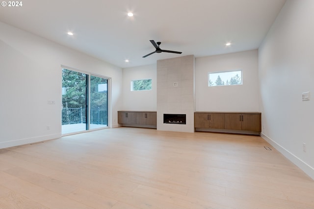 unfurnished living room featuring baseboards, light wood-type flooring, and ceiling fan