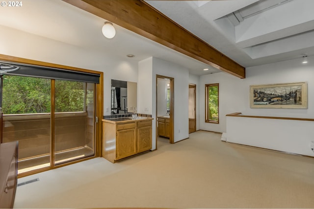 kitchen featuring beam ceiling and light carpet