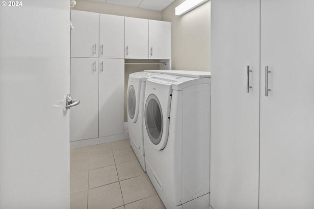 laundry area with cabinets, independent washer and dryer, and light tile patterned floors