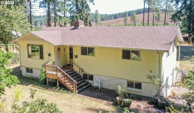 view of front of home with roof with shingles and a chimney