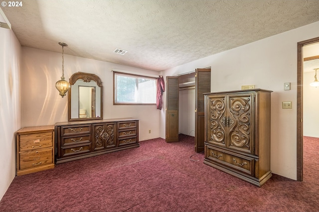 bedroom with visible vents, dark carpet, and a textured ceiling