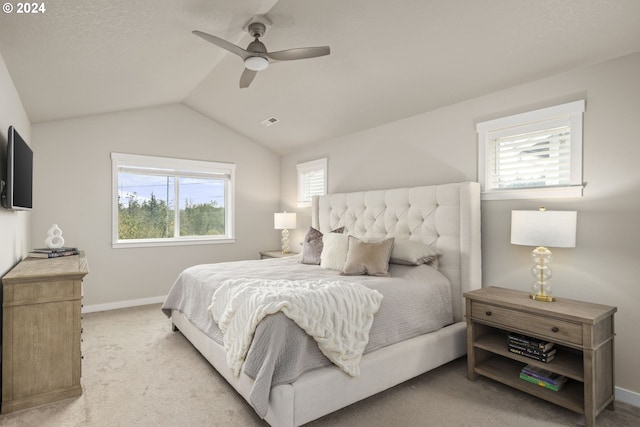 carpeted bedroom with ceiling fan and vaulted ceiling