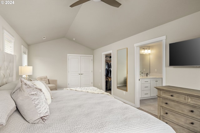 bedroom featuring a spacious closet, ensuite bathroom, ceiling fan, and lofted ceiling