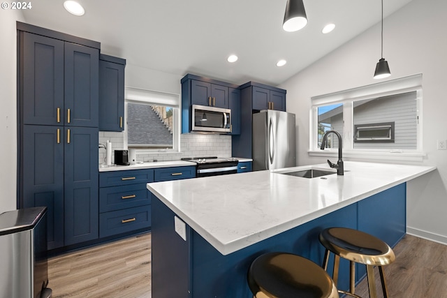 kitchen with light hardwood / wood-style flooring, backsplash, vaulted ceiling, appliances with stainless steel finishes, and sink