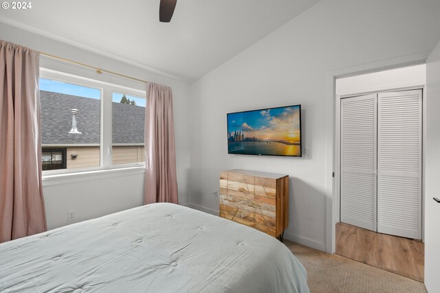 bedroom featuring carpet, a closet, lofted ceiling, and ceiling fan