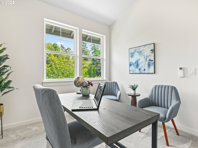 dining space featuring light carpet and baseboards