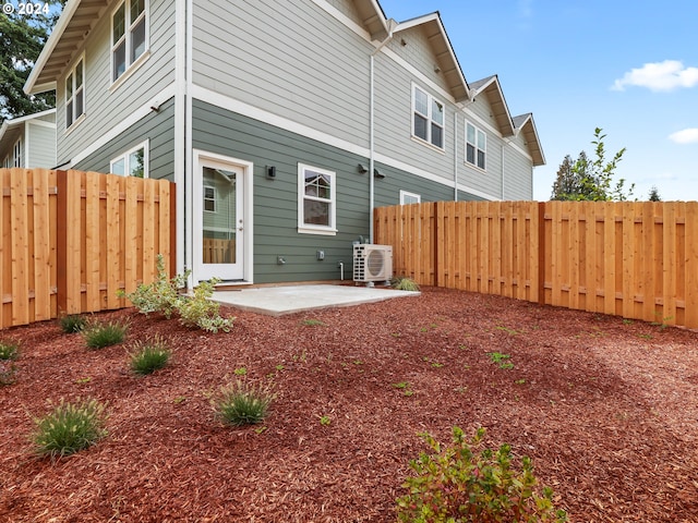 rear view of property featuring ac unit, a fenced backyard, and a patio