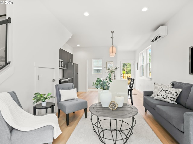 living room with light hardwood / wood-style flooring and a wall unit AC