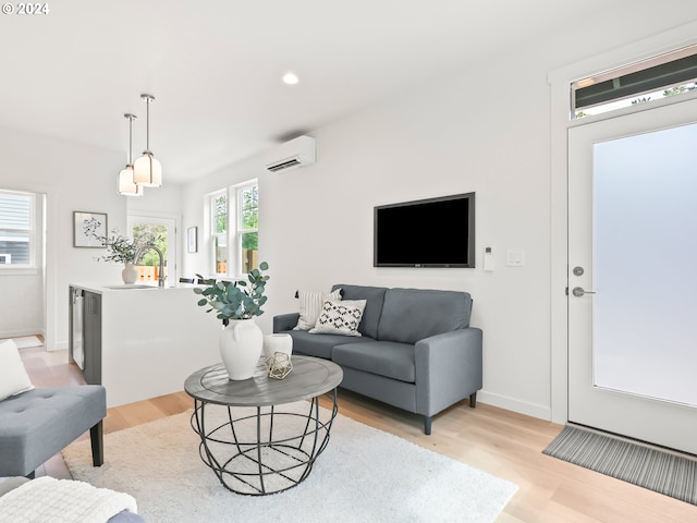 living room with baseboards, light wood-type flooring, a wall mounted air conditioner, and recessed lighting