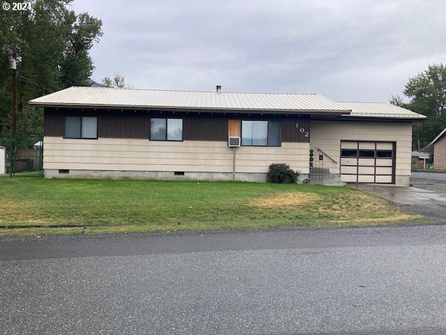 view of front of property with a garage and a front yard