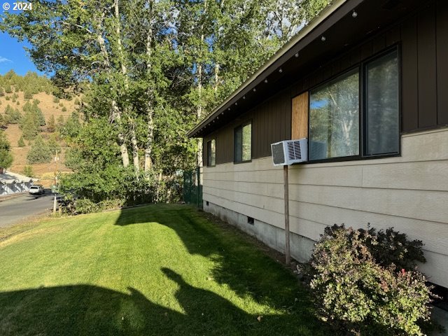 view of home's exterior featuring cooling unit and a yard