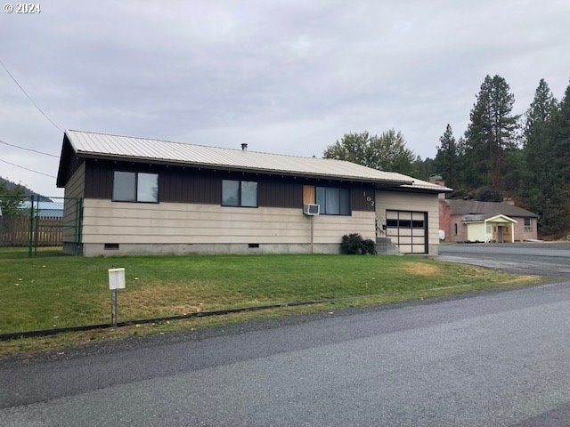 view of front of property with a garage and a front lawn