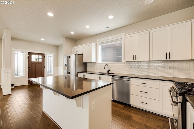 kitchen with a kitchen island, high end appliances, sink, and dark hardwood / wood-style flooring