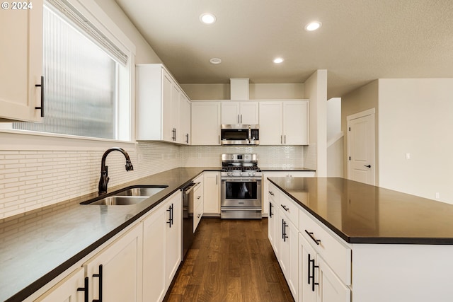 kitchen featuring tasteful backsplash, sink, stainless steel appliances, dark hardwood / wood-style floors, and white cabinetry