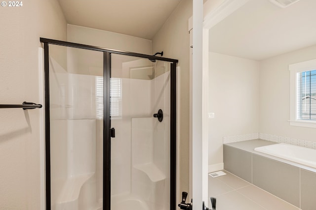 bathroom with tile patterned floors and shower with separate bathtub