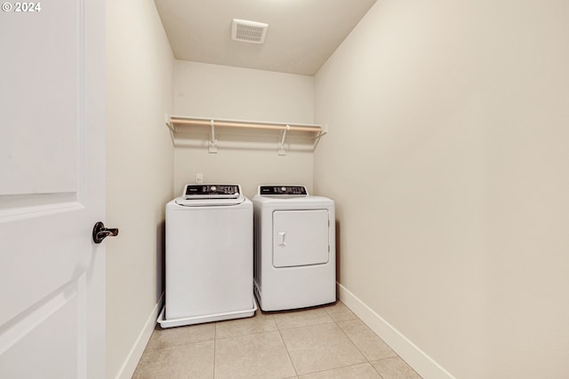 laundry room with washer and clothes dryer and light tile patterned flooring