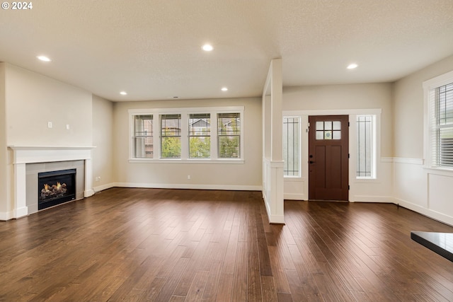 foyer with a textured ceiling, dark wood-type flooring, and a wealth of natural light