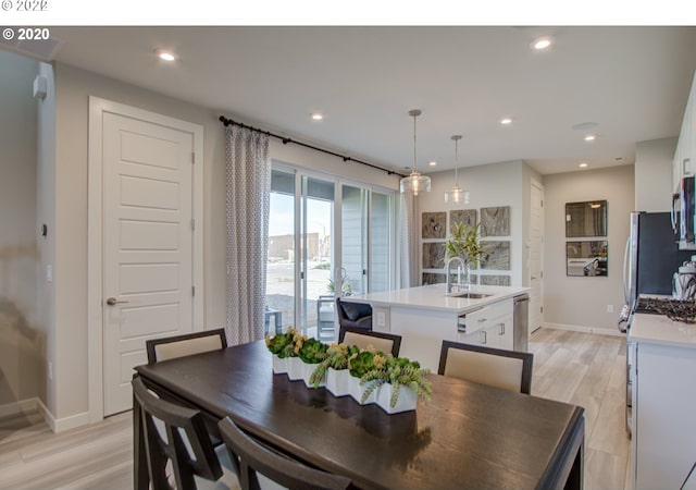 dining space featuring light hardwood / wood-style flooring and sink