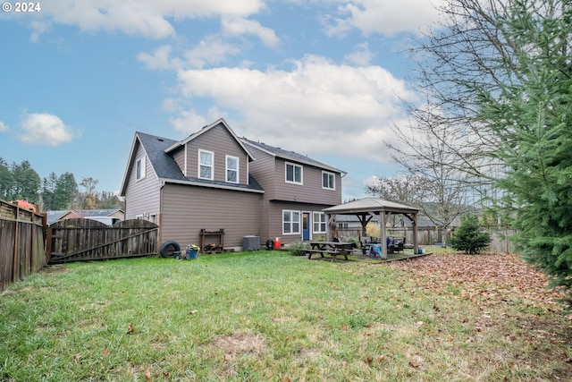 rear view of house featuring a yard and a gazebo