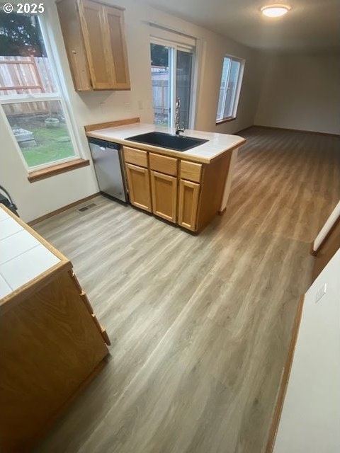 kitchen with dishwasher, light wood-type flooring, sink, and kitchen peninsula