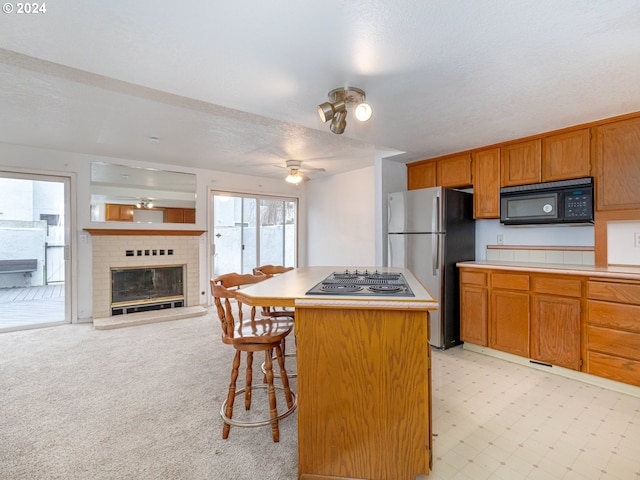 3242 NE 29th St, Gresham, OR 97030 - kitchen with freestanding refrigerator, black microwave, stovetop with downdraft, light countertops, and open floor plan