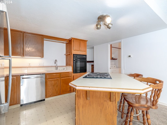 3242 NE 29th St, Gresham, OR 97030 - kitchen featuring stainless steel dishwasher, black oven, freestanding refrigerator, cooktop, and a breakfast bar