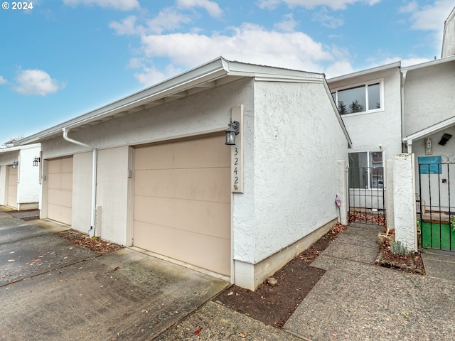 view of side of home with a garage and stucco siding