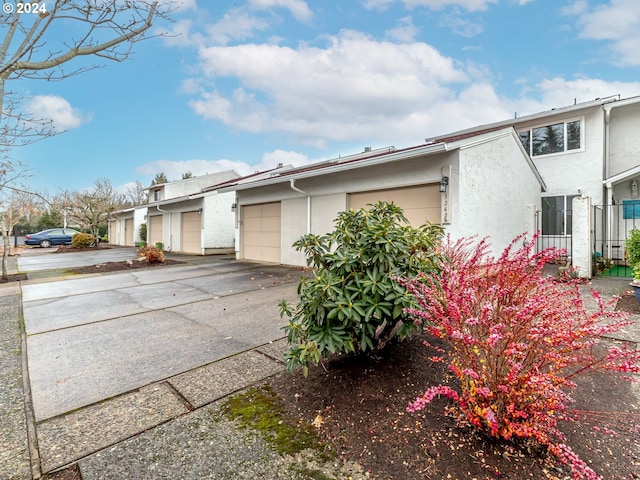 exterior space with a garage and stucco siding