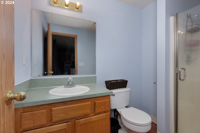 bathroom featuring an enclosed shower, vanity, and toilet