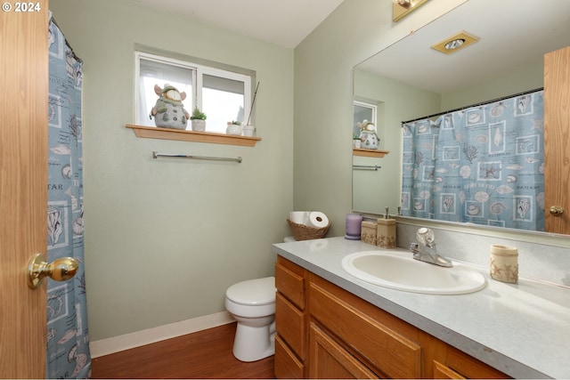 bathroom with toilet, vanity, and hardwood / wood-style flooring