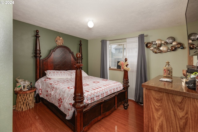 bedroom featuring a textured ceiling and hardwood / wood-style flooring