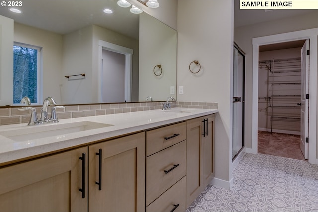 bathroom featuring vanity, decorative backsplash, and an enclosed shower