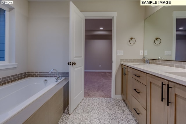 bathroom featuring vanity and a relaxing tiled tub