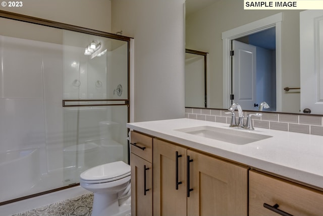 bathroom featuring vanity, toilet, walk in shower, and backsplash