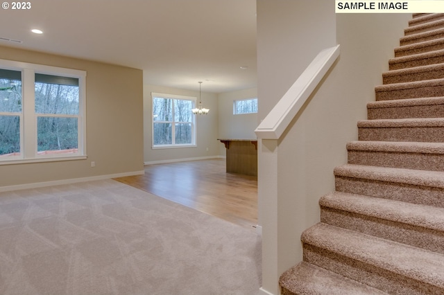 staircase featuring a chandelier and hardwood / wood-style flooring