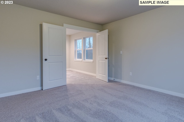 unfurnished room with light carpet