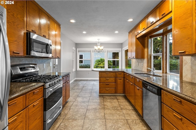 kitchen with a healthy amount of sunlight, appliances with stainless steel finishes, sink, and decorative backsplash