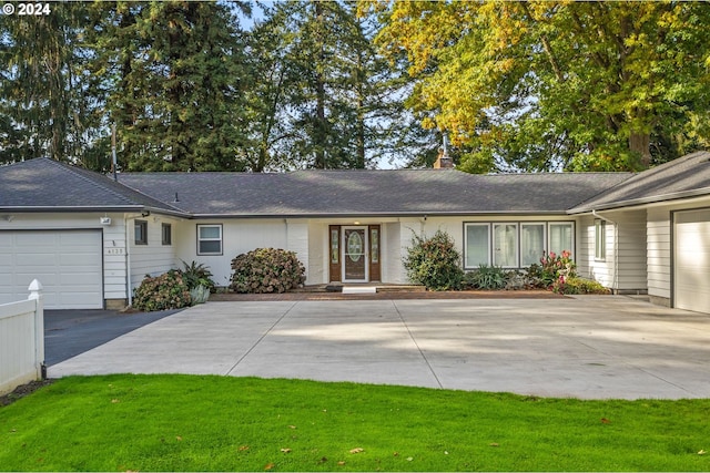 ranch-style home with a front lawn and a garage