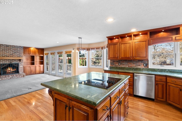 kitchen featuring dishwasher, hanging light fixtures, a center island, black electric cooktop, and light hardwood / wood-style floors