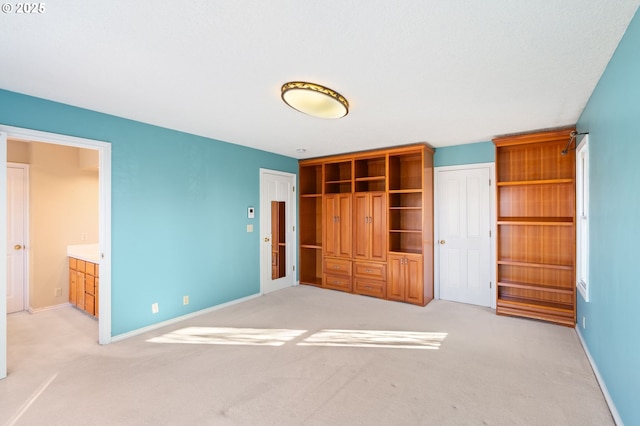 unfurnished bedroom featuring a closet, light colored carpet, and connected bathroom