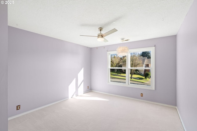 carpeted empty room featuring ceiling fan and a textured ceiling