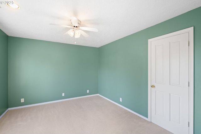 carpeted empty room featuring ceiling fan and a textured ceiling